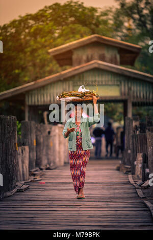 MANDALAY, MYANMAR (BURMA) - December 11, 2017: Myanmar people crossing U Bein wooden bridge at sunrise in Mandalay, Myanmar. Stock Photo