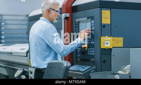 Chief Engineer/ Operator Programs/ Sets-up CNC Machine with Control Panel. He Works on the Modern Technologically Advanced Factory. Stock Photo