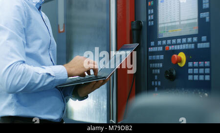 Chief Engineer/ Operator Programs/ Sets-up CNC Machine with Control Panel. He Works on the Modern Technologically Advanced Factory. Stock Photo