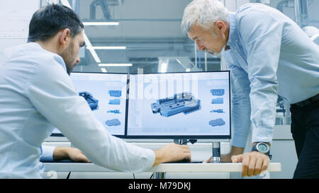 Industrial Designer Has Conversation with Senior Engineer While Working in CAD Program, Designing New Component. He Works on Personal Computer Stock Photo