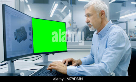 Engineer Working on a Computer with Two Displays, One has Chroma Key Great for Mockup Template and other Component in CAD Program. Stock Photo