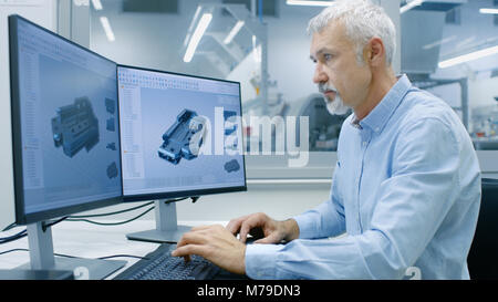 Engineer Working on a Personal Computer with Two Displays, He's Designing New Essential Component in CAD Program. Stock Photo