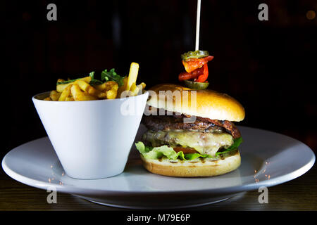 Cheese burger served in Sunderland, England. The burger is served with fries in a bowl. Stock Photo