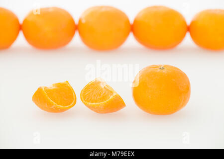 Tangerine fruits whole and pieces on a white background Stock Photo
