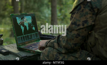 Military Operation in Action, Soldiers Using Military Grade Laptop Use Military Industrial Complex Hardware for Accomplishing International Mission. Stock Photo
