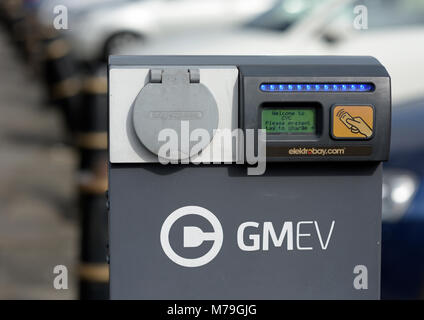 Gmev electric vehicle charging point, electric car charging point in front of soft focus blurred cars in bury council car park in lancashire uk Stock Photo