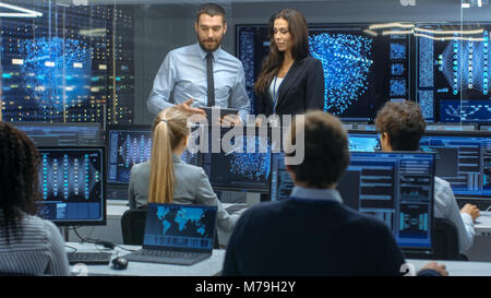 Head of the Department and Project Manager Discuss Work Process Using Data on a Tablet Computer.Multi-Ethnic Team of Engineers Working at Project. Stock Photo