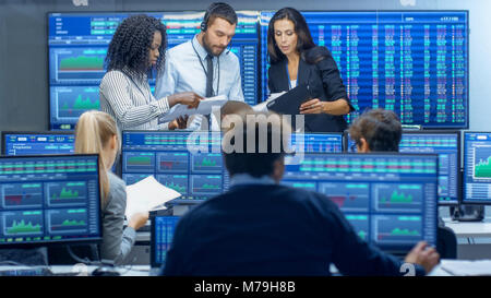 Multi-Ethnic Team of Traders is Busy Working at the Stock Exchange Office. Dealers and Brokers Buy and Sell Stocks on the Market. Stock Photo