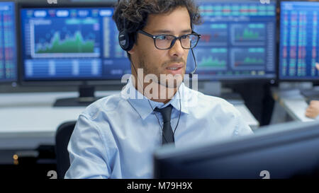 Customer Support Service Representative Talks with a Client Through Headset. He's Working in a Big Technical Consulting Company. Stock Photo