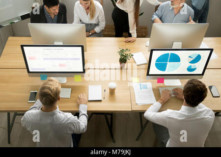 Employees using computers working with staff in office, top view Stock Photo
