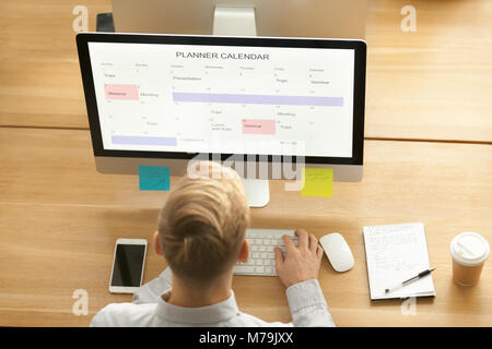 Businessman using planner application on computer in office, top Stock Photo