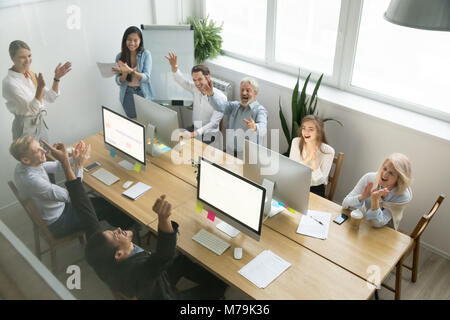 Excited diverse team congratulating black colleague with achieve