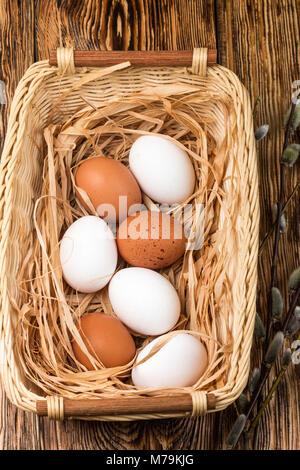 White and brown eggs in the basket on the table. Easter Stock Photo