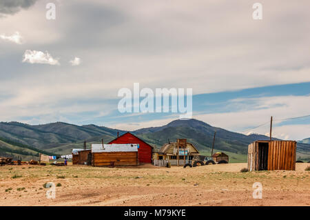 Khutag Ondor, Mongolia - July 17, 2010:  Group of isolated houses, stores & outhouses on sandy expanse of steppe in Khutag Ondor, Bulgan Province Stock Photo