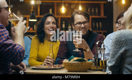 Company of Friends Having Fun in the Bar, They Drink, Talk and Joke Around. Beautiful Young People Have Good Time. Stock Photo