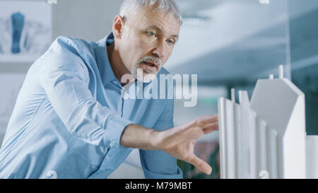 Male Senior Engineer and Female Architectural Designer Work on a Building Model Design for the Urban Planning Project. Stock Photo