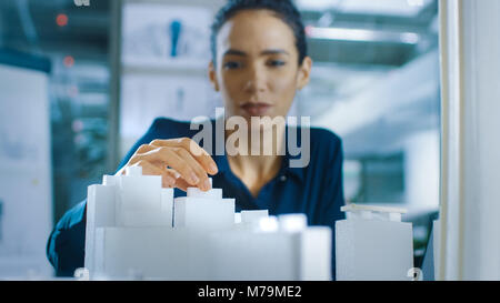 Female Architectural Designer Adds Component to a Building Model, She Works on a City District Urban Planning Project. Beautiful Woman in Office Stock Photo