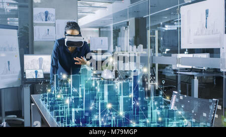 Professional Female Architect Wearing  Augmented Reality Headset Work with 3D City Model. High Tech Office Use Virtual Reality Modeling Software App Stock Photo