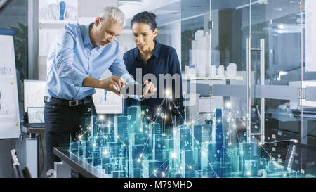 Male and Female Architects Work with Holographic Augmented Reality 3D City Model. Technologically Advanced Office Professional People Use VR Helmet Stock Photo