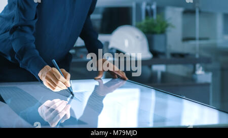 Talented Young Female Architectural Designer Draws Building Concept on a Graphics Tablet Display Vertical Touchscreen Table. Clean Minimalistic Office Stock Photo
