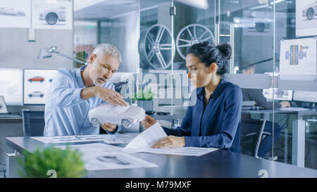 Experienced Automotive Designer and Female Engineer Works with a Concept Car Prototype Model, Perfecting it and Making Design Corrections. Stock Photo