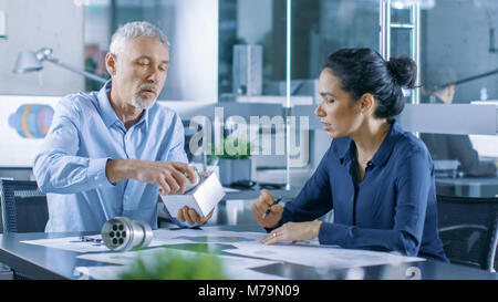Experienced Male and Female Industrial Engineers have Discussion, They Work on a Machinery Component Design. Their Office is Stylish and Modern Stock Photo