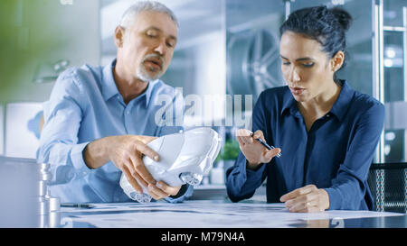 Experienced Automotive Designer and Female Engineer Works with a Concept Car Prototype Model, Perfecting it and Making Design Corrections. Stock Photo