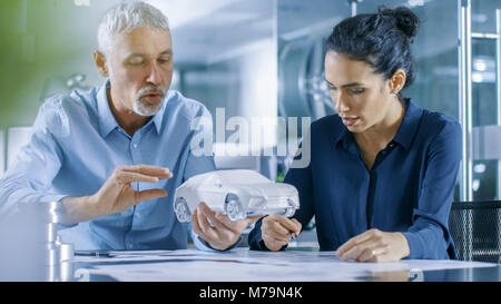 Experienced Automotive Designer and Female Engineer Works with a Concept Car Prototype Model, Perfecting it and Making Design Corrections. Stock Photo