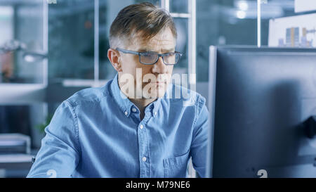 Chief Industrial Engineer Working on Personal Computer in the Stylish, Modern, Glass Office. Stock Photo