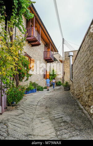 Man and woman walking up a very steep narrow road in a Cypriot village. Stock Photo