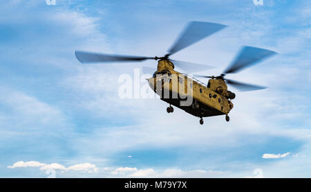 A U.S. Army Task Force Brawler CH-47F Chinook flies while conducting a personnel recovery exercise with a Guardian Angel team assigned to the 83rd Expeditionary Rescue Squadron at Bagram Airfield, Afghanistan, March 6, 2018. The Army crews and Air Force Guardian Angel teams conducted the exercise to build teamwork and procedures as they provide joint personnel recovery capability, aiding in the delivery of decisive airpower for U.S. Central Command. (U.S. Air Force Photo by Tech. Sgt. Gregory Brook) Stock Photo