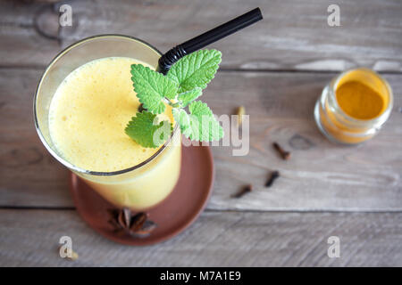 Turmeric Lassie or lassi in glass - Healthy Probiotic Indian cold drink made up of curd (yogurt), milk, spices and sugar. Turmeric Smoothie. Stock Photo