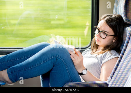 Girl reading on a train in Transylvania, Romania. Stock Photo