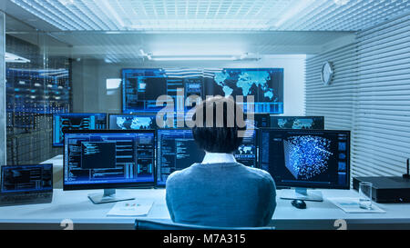 In the System Control Data Center Technician Operates Multiple Screens with Neural Network and Data Mining Activities. Room is Full of Monitors Stock Photo