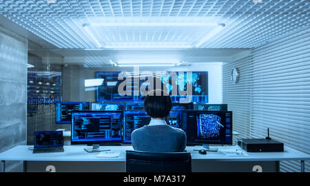 Back View of the IT Engineer Working with Multiple Monitors Showing Graphics, Functional Neural Network. He Works in a Technologically Advanced System Stock Photo