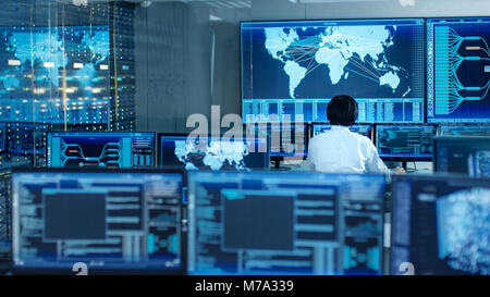 In the System Control Room Operator Sits at His Workstation with Multiple Displays Showing Graphics and Logistics Information. Stock Photo