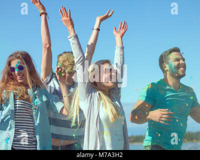 Multi-Ethnic Group of Diverse Young People Dancing in Celebration of Holi Festival. They Have Enormous Fun on this Sunny Day. Stock Photo