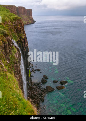 Beautiful view from Kilt Rock and Mealt Falls Viewpoint. Typical overcast weather for Isle of Skye. Big waterfall, dramatic cliffs and deep blue sea. Stock Photo
