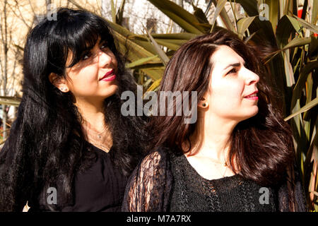 Two female students, Parisian-Algerian Faiza Faa (left) with her friend Samar Munaf from Iraq (right) looking up to the skies in Dundee, UK Stock Photo