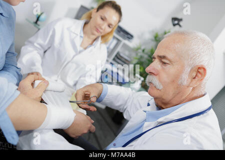 doctor applying a plaster cast and bandages to patient Stock Photo