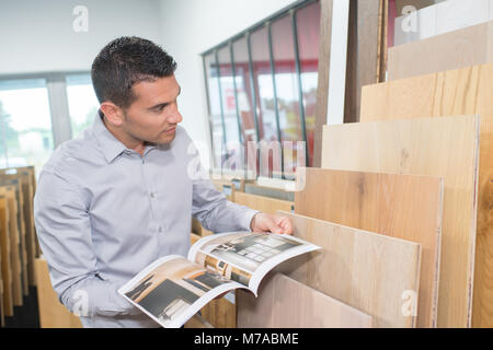 customer in hardware store choosing wood strip for diy-project Stock Photo