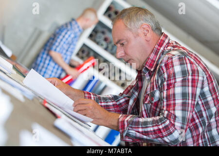 senior contractor at desk doing paperwork Stock Photo