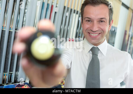 young handsome businessman holding billiard ball Stock Photo