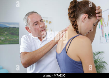 mature physiotherapist doing spine mobilization Stock Photo