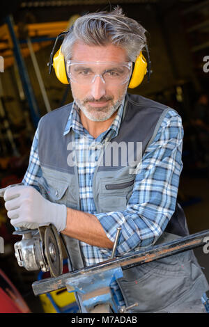 Portrait of man using angle grinder Stock Photo