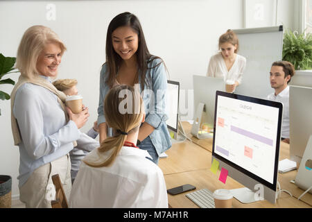 Smiling multiracial businesswomen colleagues of different age ta Stock Photo