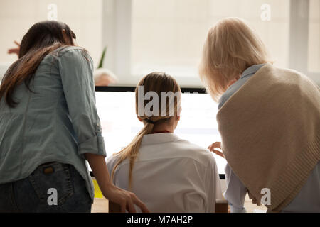 Three businesswomen working together on computer online task, re Stock Photo