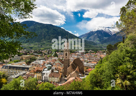 The city of Merano with Church of St. Nicholas in South Tirol in front of alpine scenery, seen from the Tappeinerpromenade above the town Stock Photo