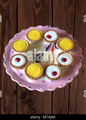 a selection of bakewell and lemon tarts on a wooden background Stock Photo