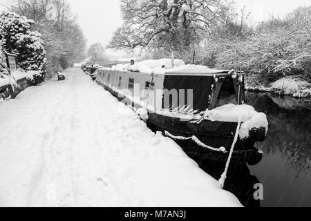 Narrowboats covered in snow are seen moored up on the Llangollen Canal Stock Photo